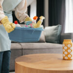 dark haired woman carrying basin with difinfection appliances