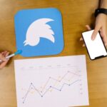 person holding mobile phone analyzing twitter graph 23 2147847487